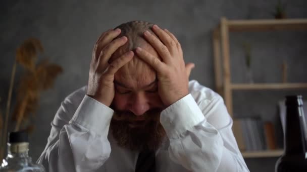 Concepto de alcoholismo. La adicción al alcohol, un hombre en una borrachera entre botellas de bebidas, un hombre de negocios barbudo borracho, el problema del tratamiento del alcoholismo. — Vídeos de Stock