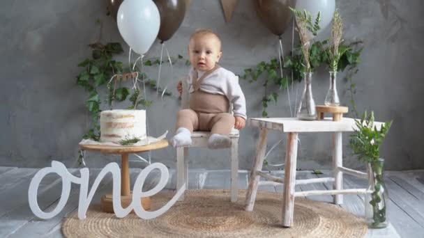Babys aniversário, decoração natural para o primeiro ano, bebê no fundo de balões e bolo, decoração de estilo rústico, bebê feliz um ano feriado. — Vídeo de Stock