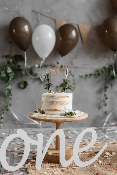 赤ちゃんの最初の誕生日の装飾 ケーキや風船を背景に 木製の文字1 素朴なミニマリストスタイル 1歳の誕生日 — ストック写真