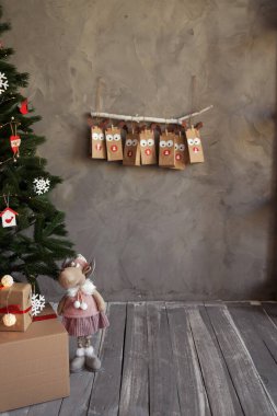 Noel kutlaması el işi paketleme takvimi duvarda asılı, kış tatilinde oda dekorasyonu, gri arka plan, el yapımı hediyeler konsepti