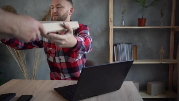 Een portret van een man met een baard die thuis aan een project werkt, pizza bestelt en geniet van de fastfood levering. — Stockvideo