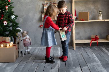 Çocuklar, hediye paketleri ile bir numaralı takvim, el yapımı paketleme takvimi, yeni yürümeye başlayanlar için on sentlik hediyeler, Noel çocuk konsepti, mevsimlik gelenekler