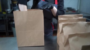 Yemek teslimatı, şef konteynırları paketlere koyar, paketler masaya, iş yemeği teslimatı, küçük işletme servis restoranı, paket yemek.