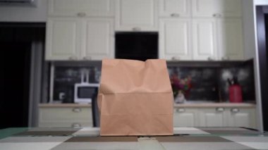 Evde, günlük kıyafetlerle oturan beyaz kadın internetten sağlıklı organik yiyecekler alırken bir paket açma paketi açtı. Genç etnik kadınlar bir kutuyu açıyor, internetten alışveriş yapıyorlar..