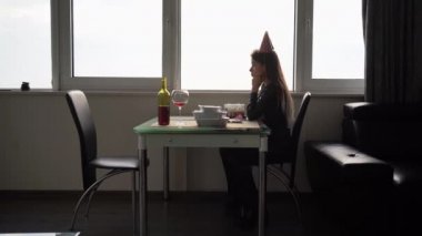 Yalnız doğum günü, kederli kız 25 yaşında, birinci yıldönümünü kutluyor, doğum gününü evde yalnız geçiriyor, genç ve güzel bir kadın pencere kenarında bir masada oturuyor.
