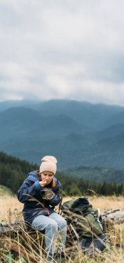 Dağlardaki kız turistler gezginlerin özel yemeklerini yerler, doğada hazır erişteler. Gezgin yemeği konsepti. Yatay pankart. Metin için yer