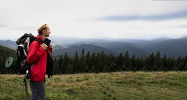 Dağ turizmi, sırt çantalı bir gezgin gökyüzüne bakıyor, Alps dağları arka planı, aktif yaşam tarzı, macera yolculuğu, afiş için yer