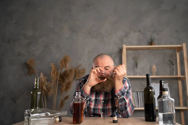 Adult Bearded Man Sits Table Casual Clothes Holds Glass Whiskey — Stock Photo, Image