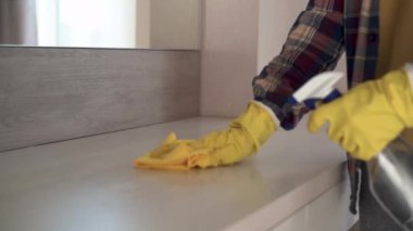 Sarı lastik eldivenli erkek elleri mobilyaların tozunu siliyor. Mobilyalar için temizlik aracı.