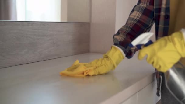 Close-up dari tangan laki-laki dalam sarung tangan karet kuning menyeka debu dari furnitur. membersihkan agen untuk furniture. — Stok Video