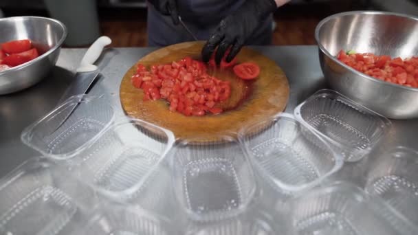 Matleveransservice. En kvinnlig hand skär en rå tomat med en kniv på en skärbräda. Nätbeställning och leverans koncept. Läcker hälsosam balanserad hämtmat. — Stockvideo