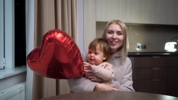 Anya és a baba beszélnek egy videohívás, webkamera nézet, boldog család kommunikálni online otthon, Valentin nap szív léggömb babák kezében — Stock videók