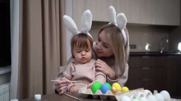 Mother and daughter paint Easter eggs. Happy family is preparing for Easter. make a video call and communicate via video communication. — Stockvideo
