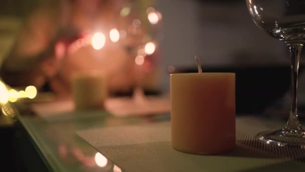 Una mesa con vino y copas para una cena romántica para dos, una mano de mujer enciende velas. Fecha romántica para el día de San Valentín 14 de febrero o aniversario. — Vídeo de stock