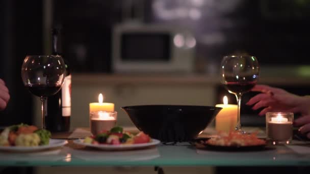 Szklanki wina trzymają je mężczyźni i kobiety. Romantyczna kolacja. Data koncepcja na Walentynki 14 lutego lub rocznica. — Wideo stockowe