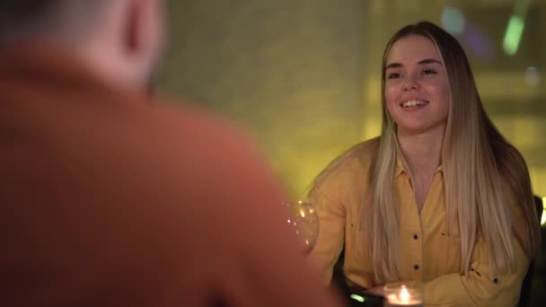 Candlelight dinner at home. couple in love is sitting at the table and talking cute. Womans portrait over the shoulder. concept for celebration of valentines day or anniversary. — Video Stock
