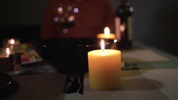 Gros plan de bougies allumées à la maison sur une table lors d'un dîner romantique pour la Saint-Valentin ou l'anniversaire. Concept zen et détente. — Video