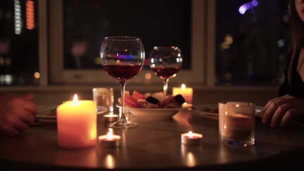 Під час романтичної вечері за столом, чоловічі та жіночі руки об'єднуються разом, впритул вибірковий фокус. Концепція святкування дня валентинки, річниці або річниці . — стокове відео
