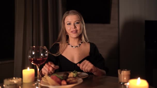 Romantic date, woman on valentines day with red wine and candlelight, dinner at home for wedding anniversary, adult sexy girl in black dress at table — Stok video