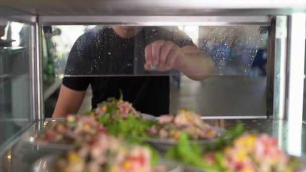 Showcase salad bar with an assortment of food for healthy and dietary meals. Take-out salad. Caucasian man opens the fridge showcase and takes a plate of food. Buffet concept, — Video Stock