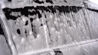 window regulator with white soap foam. Car care business. Car cleaning and polishing before waxing. Car wash service with antiseptic and disinfection.