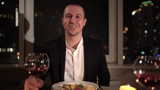 POV portrait of a man in the evening sits at a table during a romantic dinner at home. The guy is given a box with a gift. concept for celebration of valentines day, anniversary, birthday — Wideo stockowe