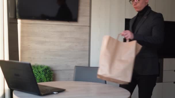 Food delivery home office, man unpacking lunch bag in disposable dish, businessman freelancer food takeaway, eating at home — Wideo stockowe