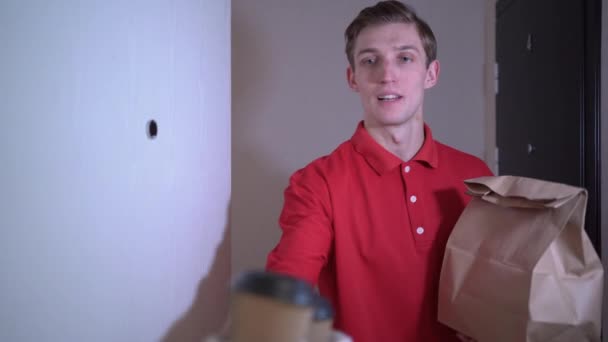 A POV man opens the door and is greeted by a food delivery courier. Takeaway food concept. — Αρχείο Βίντεο