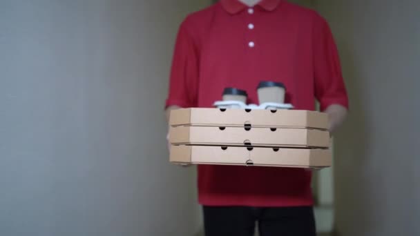 Close-up of couriers hands and pizza. Portrait of a delivery man, a man carries a lot of boxes along the corridor of the house, courier food delivery. Delivery man holding hot , food ordering online. — Vídeo de Stock