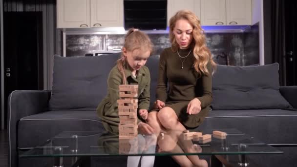 Family at the table plays a board game, mom and daughter spend time together. — Stock Video