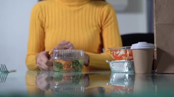 Mujer comiendo verduras de una caja de plástico, ensalada vegana en un contenedor de un servicio de entrega, comida orgánica en casa, loncheras con comida — Vídeo de stock