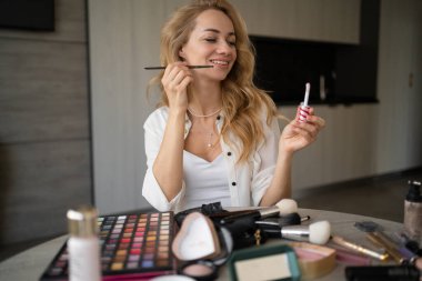 Genç beyaz kadın profesyonel güzellik blogcusu veya vlogger bunu sosyal medyada paylaşmak için makyaj dersi yazıyor. Fırçanın ne olduğunu söylüyor. Çevrimiçi öğrenme kavramı. webcam görünümü