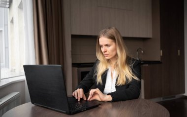 Dizüstü bilgisayar kullanan, internetten e-posta haberlerini kontrol eden ciddi serbest çalışan bir kadın, evde uzaktan çalışan bir iş kadını, ev ofisinde serbest çalışan, blog yazan ya da internet kullanıcısı eğitim ağı izleyen bir kadın.