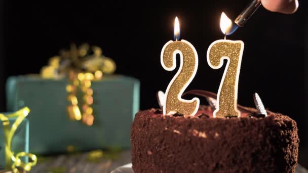 27 numaralı mumlu doğum günü pastası parlak bir şenlik arka planında, çakmağından ateş, 27 yıl söndür.. — Stok video