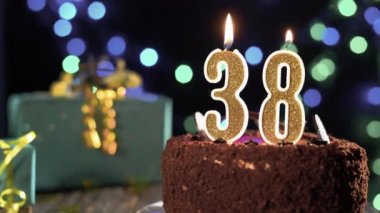 Doğum günü mumu 38 numara masadaki tatlı kekin üstünde, 38. doğum günü. Çakmağı yak, bayram mumunu söndür..