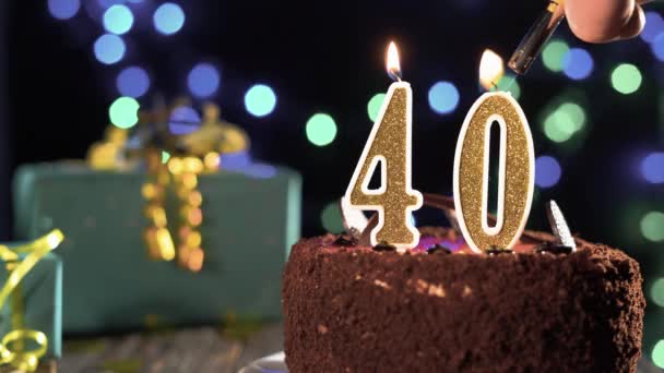Świeczka urodzinowa numer czterdzieści na słodkim torcie na stole, 40 urodziny. Ogień z zapalniczki, zdmuchnij świąteczną świeczkę. — Wideo stockowe
