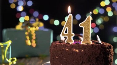 Doğum günü mumu 41 numara masadaki tatlı kekin üstünde, 41. doğum günü pastası. Çakmağı yak, bayram mumunu söndür..