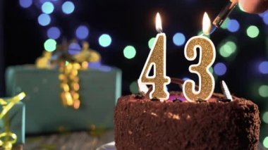 43 numaralı doğum günü mumu masadaki tatlı kekin üzerinde, 43. doğum günü. Çakmağı yak, bayram mumunu söndür..