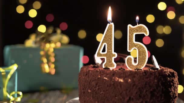 Fünfundvierzigste Geburtstagskerze auf einem süßen Kuchen auf dem Tisch, 45. Geburtstag. Feuer aus dem Feuerzeug, Feiertagskerze ausblasen. — Stockvideo