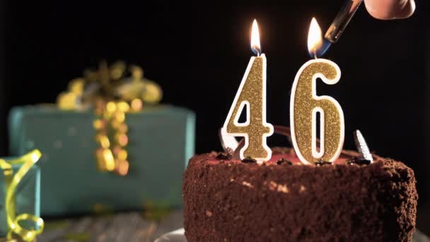 Número quarenta e seis vela de aniversário em bolo doce na mesa, 46 anos. Fogo do isqueiro, apaga a vela do feriado. — Vídeo de Stock