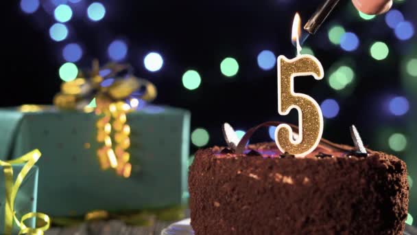 Bougie d'anniversaire gâteau d'or numéro 5 cinquième feu de briquet soufflant des bougies. Espace de copie sur le côté gauche de l'écran. — Video