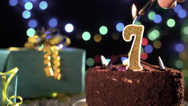 День рождения торт золотая свеча номер 7 Седьмой огонь от зажигалки задувая свечи. Копировальное пространство в левой части экрана. — стоковое видео