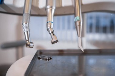 Modern dişçi aletlerini kapatın, arka planı bulanık cilalama makineleri. Boşluğu kopyala.