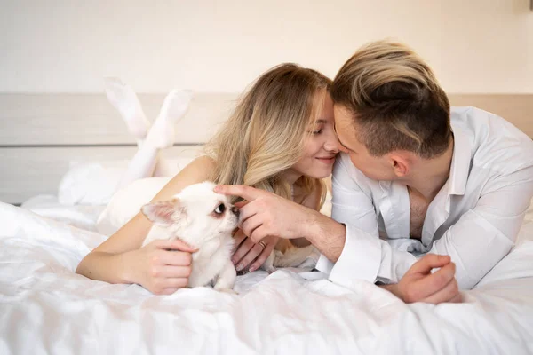 Een Paar Verwennen Een Hond Die Thuis Het Bed Zit — Stockfoto