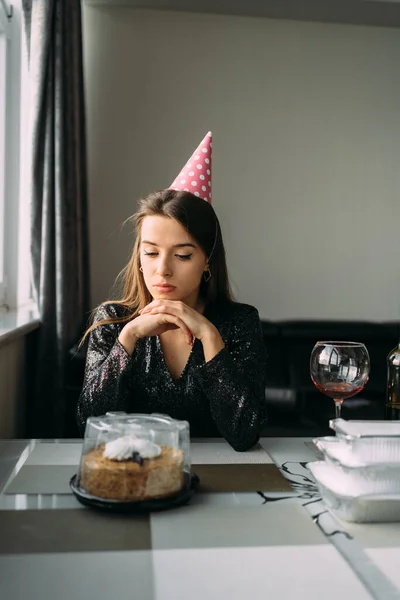 Gyönyörű Felnőtt Lány Sapkában Szomorú Születésnapján Egy Asztalnál Egy Tortával — Stock Fotó