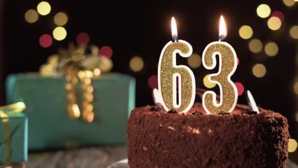 Candela numero sessantatré su una torta dolce sul tavolo, sessantatreesimo compleanno. Fuoco dall'accendino, spegnete la candela natalizia. — Video Stock