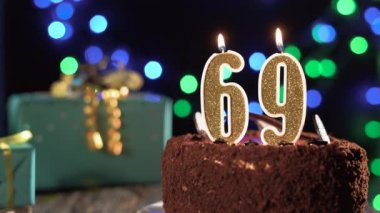 69 numaralı doğum günü mumu, 69 'uncu doğum gününde masadaki tatlı kekin üzerinde. Çakmağı yak, bayram mumunu söndür..
