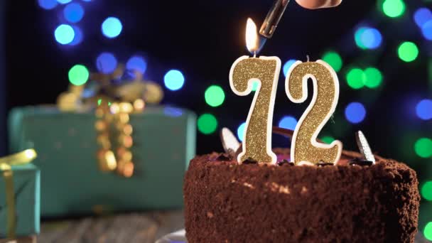 Bougie d'anniversaire numéro 72 sur un gâteau sucré sur la table, 72e anniversaire. Feu du briquet, éteindre la bougie de vacances. — Video