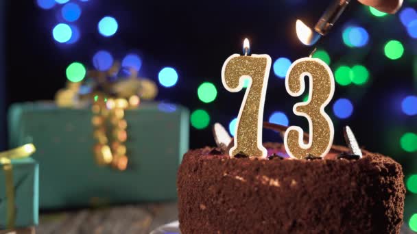 Vela de cumpleaños número setenta y tres en un pastel dulce en la mesa, 73 cumpleaños. Fuego del encendedor, apague la vela navideña. — Vídeos de Stock