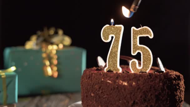Číslo sedmdesát pět narozeninové svíčky na sladkém dortu na stole, 75. narozeniny. Oheň ze zapalovače, sfoukni sváteční svíčku. — Stock video
